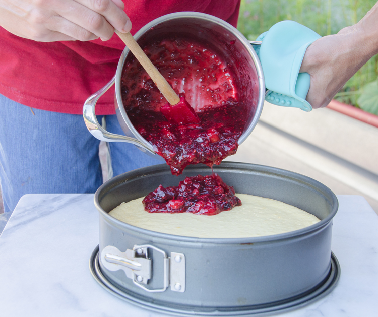 Pouring rote Grütze onto cheesecake 1