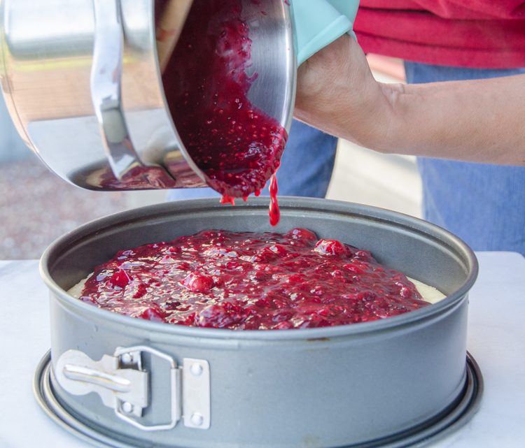 Pouring rote Grütze onto cheesecake 3